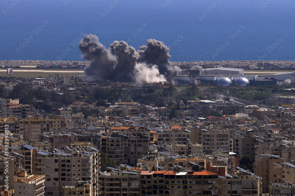 Naklejka premium Baabda, Lebanon - April 11 2026: Smoke rises following an Israeli strike on the southern suburbs of Beirut as seen from Baabda illustrating ongoing conflict in the region