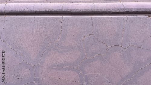 Fotografi Close‑up of a pale lilac plaster facade with fine cracks and worn paint beneath