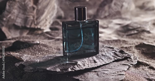 Aromatic blue perfume on dark volcanic rock.