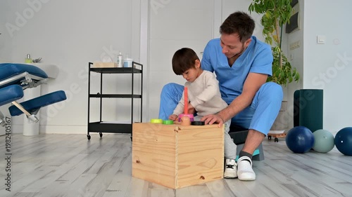 Child with disability performing motor skills exercises with physiotherapist using educational game. Pediatric rehabilitation, coordination development, therapy and healthcare concept. High quality 4k