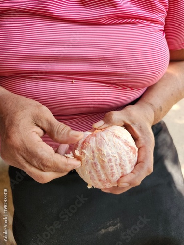 Senior Woman Peeling a Fresh Grapefruit