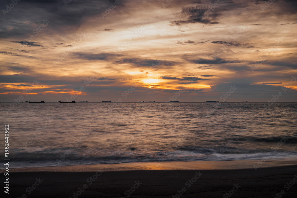 Fototapeta premium golden hour sunset over Melaka or Malacca Straits coastal beach and sea at Pantai Puteri