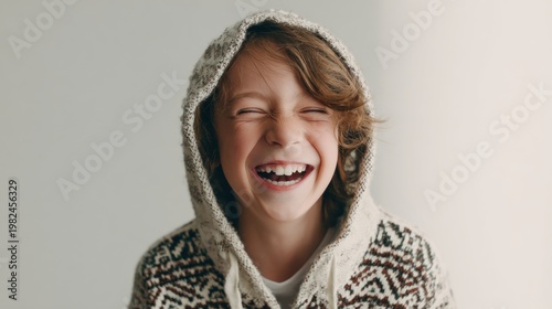 Joyful young boy with a wide smile wearing a cozy knit hoodie capturing pure happiness