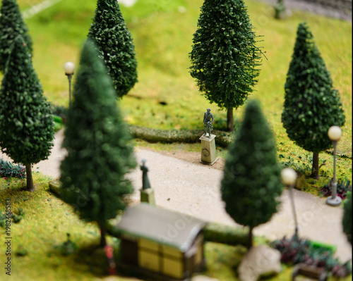 Miniature models of statues standing on the tree-lined avenue in the park