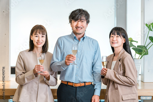 Bilde på lerret Businessmen and businesswomen line up in the office with champagne bottles (team
