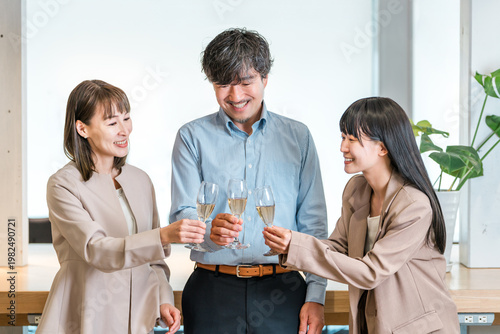 Foto Businessmen and businesswomen line up in the office with champagne bottles (team