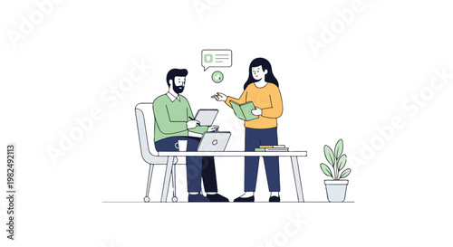 A man sits at a desk using a laptop while a woman stands beside him, holding a book and discussing ideas in a modern, minimalist workspace.