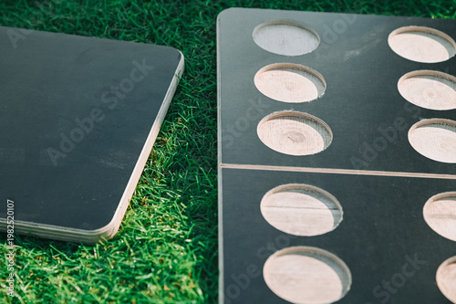 Wooden Game Board with Circular Holes on Grass, Outdoor Setup
