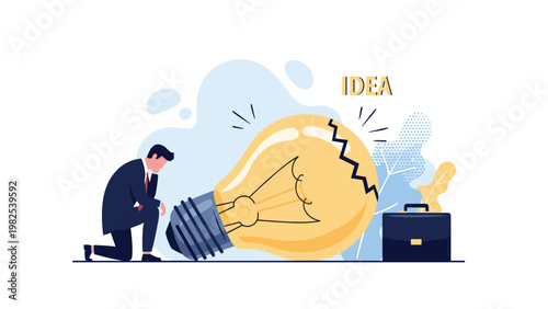 Sad businessman kneeling beside a giant broken lightbulb to represent a failed idea or loss of creative inspiration.
