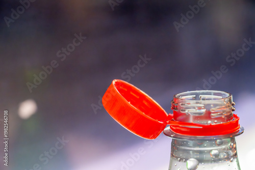 Bottle with orange cap sitting on table indoors during daytime