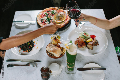 Konstfotografi two girls clink glasses of champagne on a beautiful summer terrace, fine dining