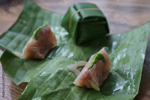Authentic Thai Naem Moo or fermented pork sausage in selective focus. wrapped in banana leaf