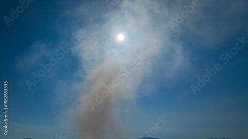 Aerial view of Landfill Fire Environmental Damage. Environmental hazard scene showing a burning landfill in Phuket city with dense white smoke drifting into the sky.