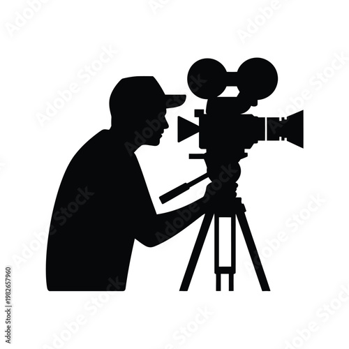A silhouette of a man operating a large video camera