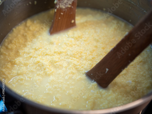 Quadro su tela Cooking traditional Easter egg cheese (hrudka) in a pot, curdling eggs mixture close to completion, close-up food preparation