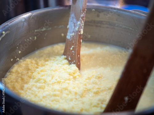 Tableau sur toile Cooking traditional Easter egg cheese (hrudka) in a pot, curdling eggs mixture close to completion, close-up food preparation