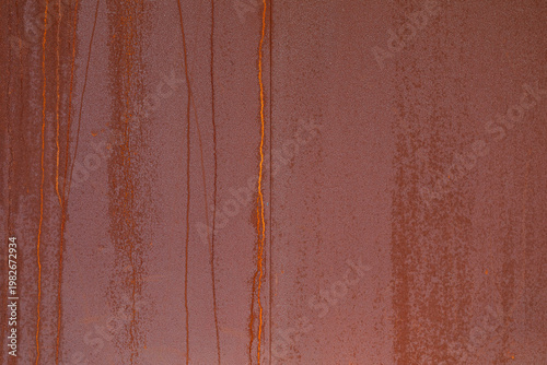 weathered reddish brown metal surface with vertical rust streaks