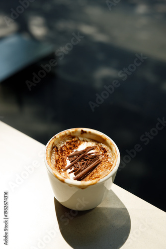 Cup of hot milk latte coffee on table by the window.