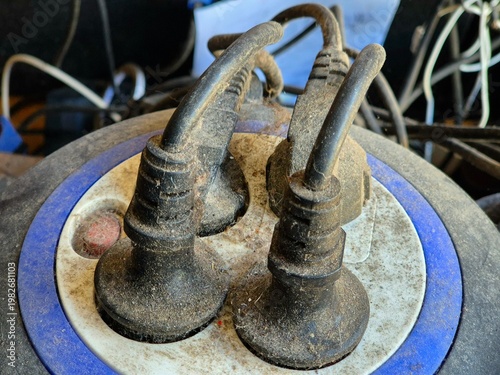 Dusty power strip with multiple plugs connected showing cluttered cables and poor maintenance in close-up