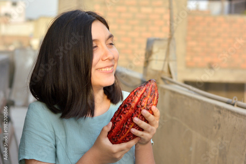 Latin teenager girl holding cocoa bean.