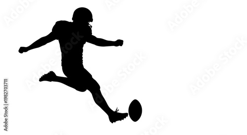 Silhouette of a football player kicking the ball during a game