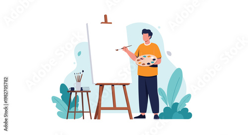 Creative male artist standing at an easel and painting on a white canvas with a palette and brushes in his own art studio.