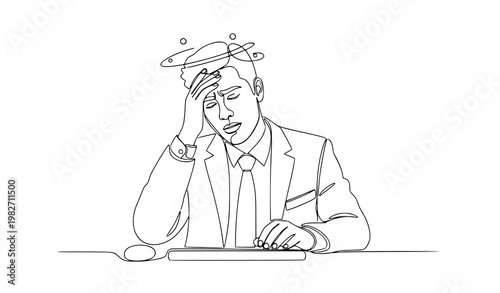 A stressed businessman sitting at a desk with a worried expression