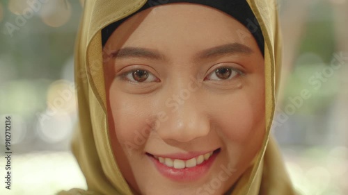 Close-up portrait of a young Muslim woman in hijab smiling warmly, representing confidence, identity, and positive lifestyle.
