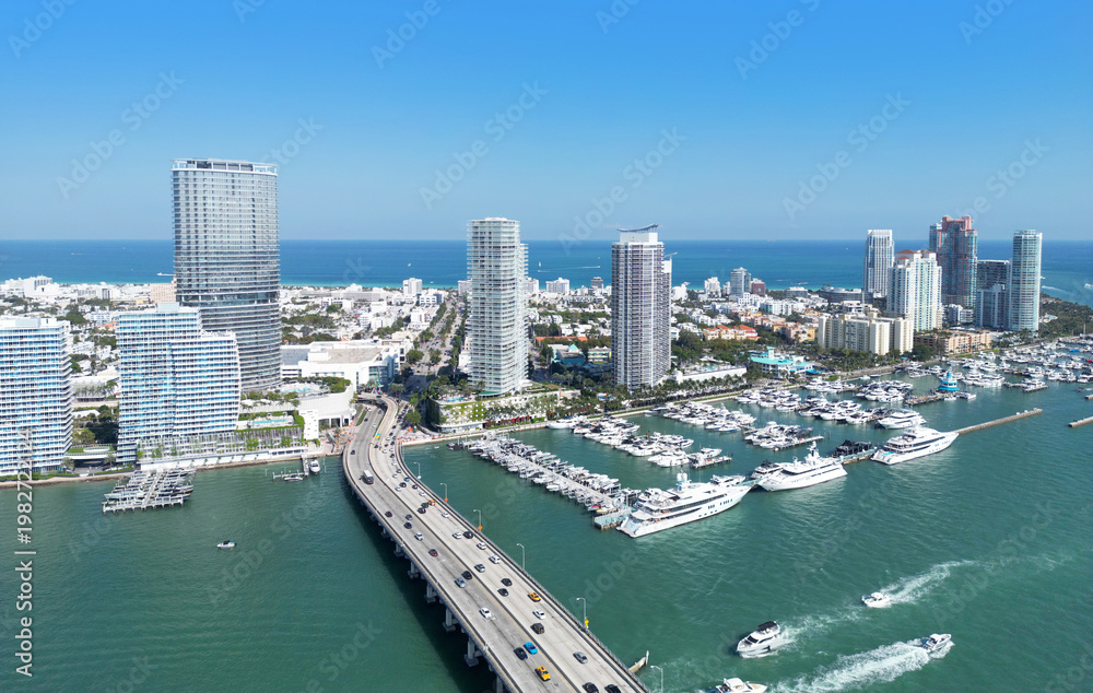 Fototapeta premium Miami district sky view. Drone shot of Miami on sunny summer day. Miami Beach downtown. MacArthur Causeway in Miami. Biscayne Bay bridge.