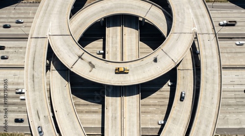 Aerial view of a complex highway interchange with a single car on the road, showcasing the intricate design of modern infrastructure and transportation systems