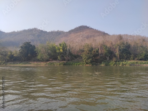 Traditional River Boat with Lao Flag and Mountain Landscape