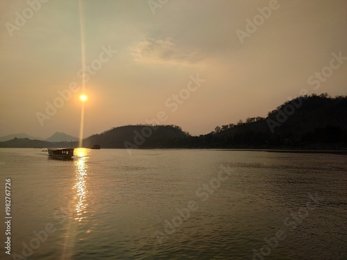 Traditional River Boat with Lao Flag and Mountain Landscape