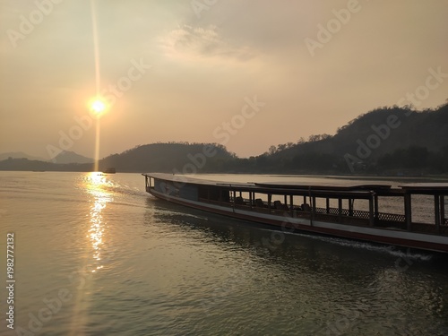 Traditional River Boat with Lao Flag and Mountain Landscape