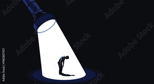 Silhouette of a person bowing their head while standing in the bright circular beam of a large handheld flashlight.