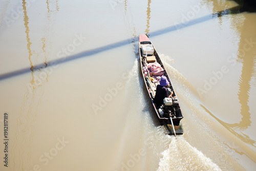 Life Lifestyle local thai people and old man drive sailing antique wooden boat longtail Canal of Community Village in Hua Takhe Old Market or Hua Ta Khe Bazaar at Lat Krabang city in Bangkok, Thailand
