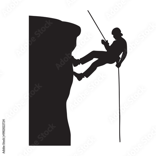 Silhouette of person rappelling down a steep rock cliff