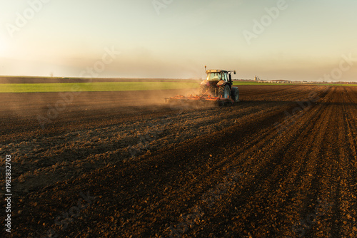 Farmer in tractor preparing land for sowing