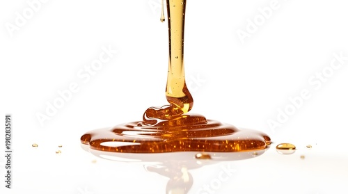 A close-up shot of golden honey pouring and creating ripples on a white surface, showcasing its viscous texture and natural sheen