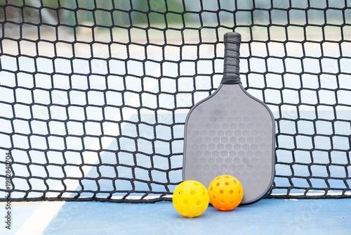 Obraz na płótnie Pickleball paddle and balls resting on court