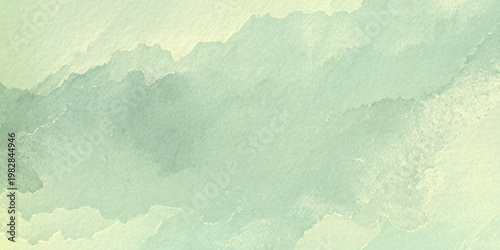 Soft green watercolor texture background with abstract cloudy shapes and subtle gradient effect for design and artistic use