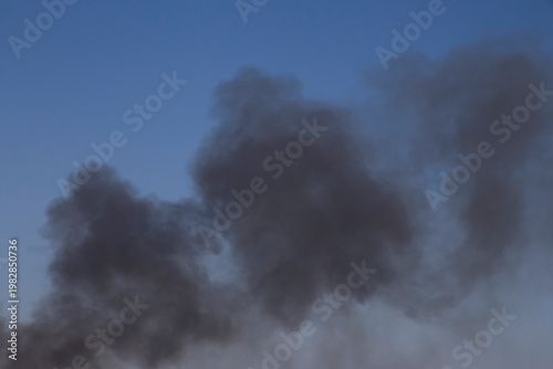 black smoke from the fire in a clear blue sky