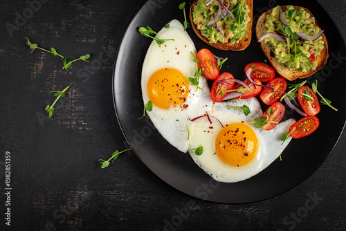 Protein rich brunch with sunny side up eggs and avocado toast, flat lay