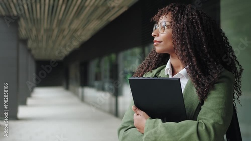 Pensive African American Businesswoman with laptop Looking Through Office Window