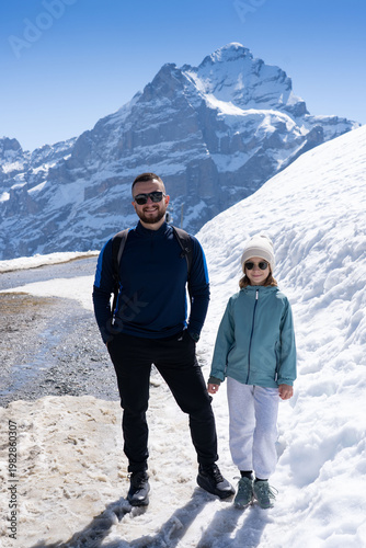men with daughter hiking in the Swiss Alps mountains during vacation, Grindelwald, First Cliff Walk