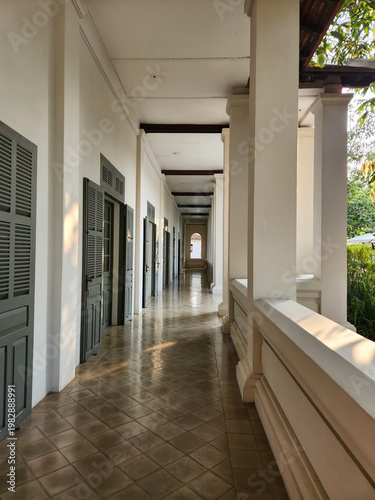 Long Colonial Corridor with White Columns and Gray Shutters