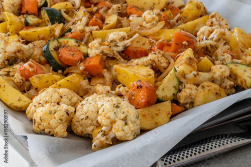 Stockholm, Sweden  Raw marinated potatoes and cauliflower on a baking pan for roasting.
