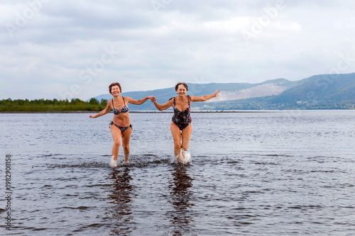 athletic elderly women run on the waves of the river