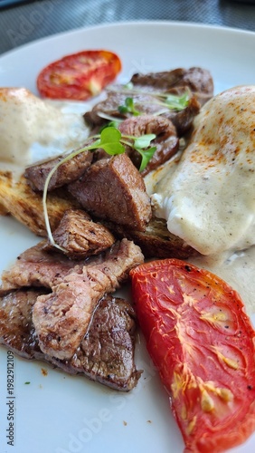 Grilled tenderloin beef served with toasted sourdough, poached eggs, hydroponic lettuce, baked tomatoes, and Trinade sauce.