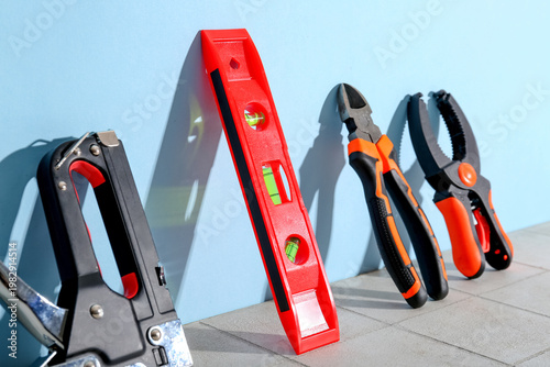 Bilde på lerret Spirit level and tools leaned against blue wall