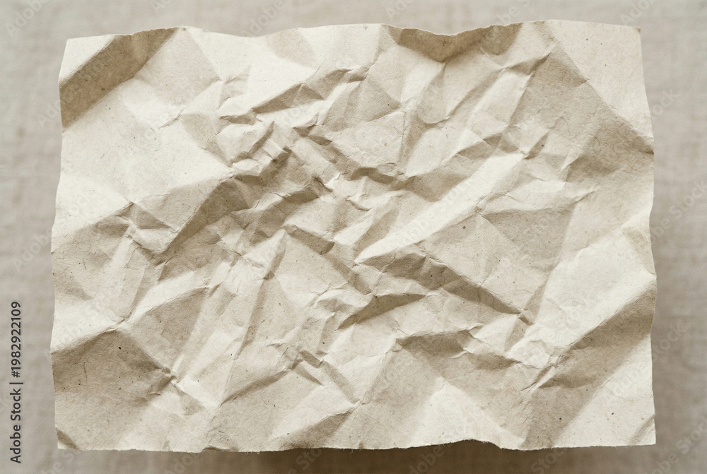 Obraz premium Crumpled beige craft paper texture for background with natural shadows and complex sheet creases organic
